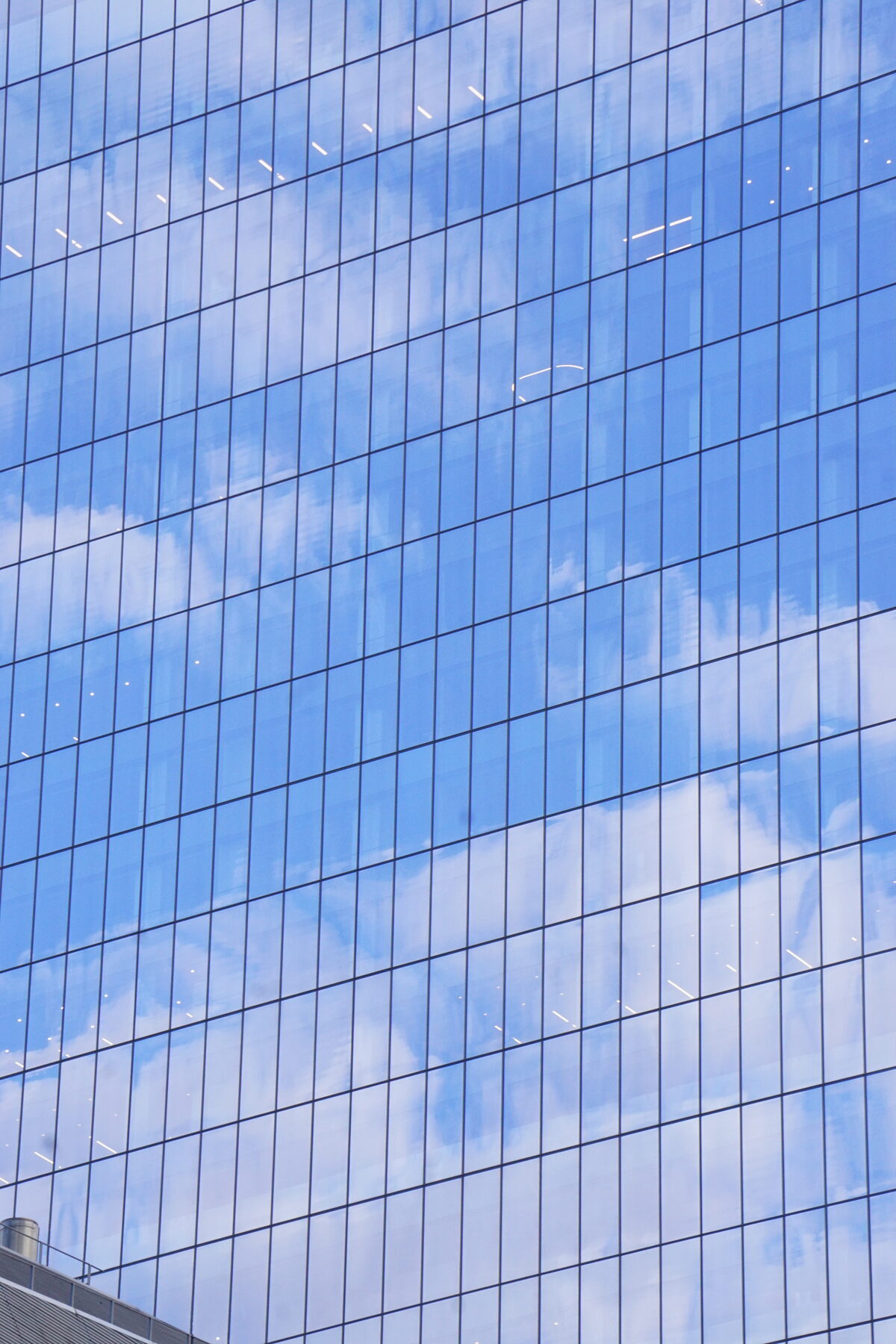 Clouds reflected in a glass skyscraper facade grid